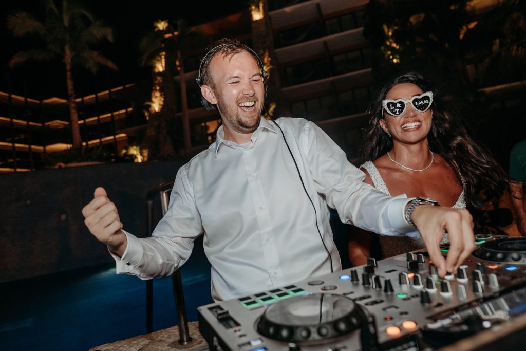Hotel-Xcaret-Mexico-Wedding-Travis-Lucy-Pixan8413: Groom DJing with guests cheering Riviera Maya wedding